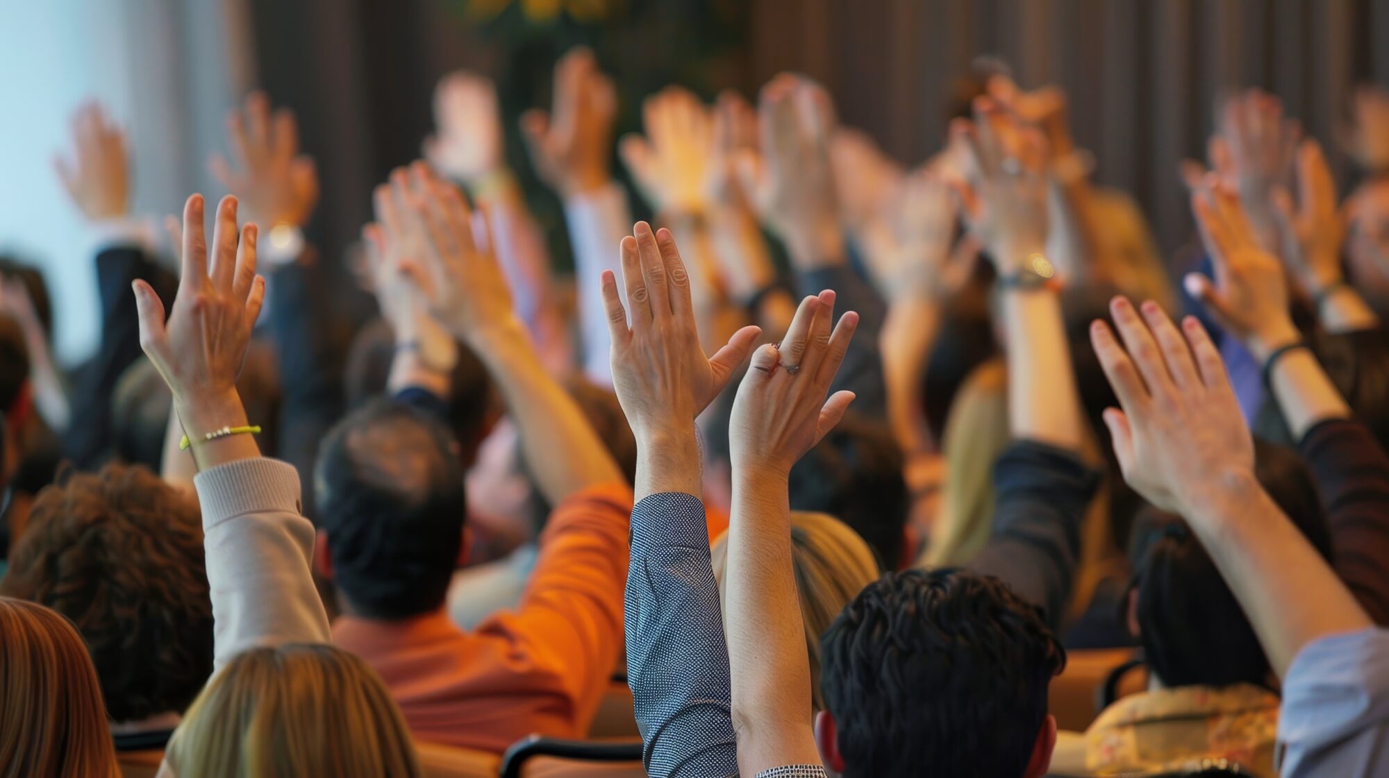 Community assembly with people raising their hands
